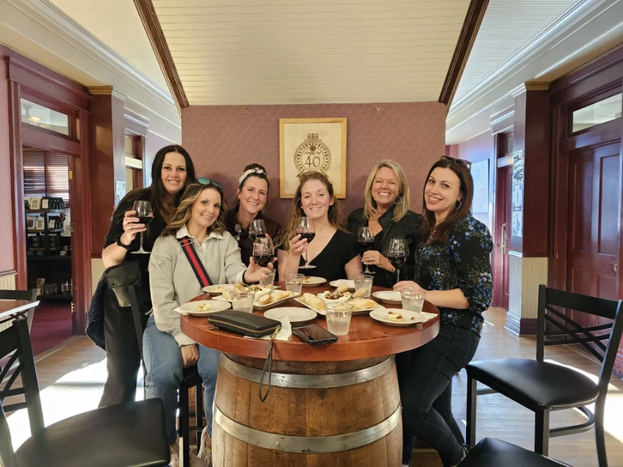 Group of women enjoying wine and food during a wine tour in Grapevine, TX.