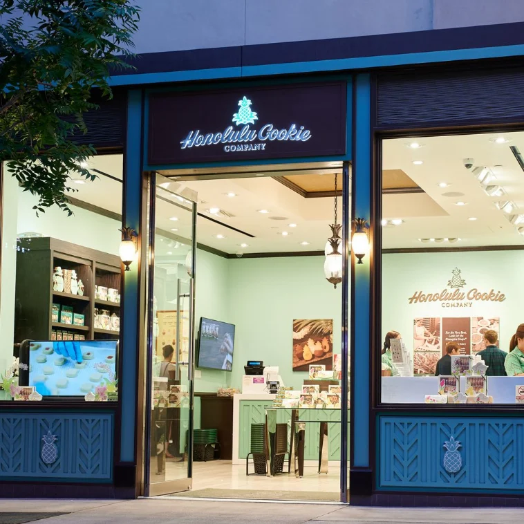 Honolulu Cookie Company storefront in Las Vegas, featuring a mint green interior with display shelves and a welcoming entrance